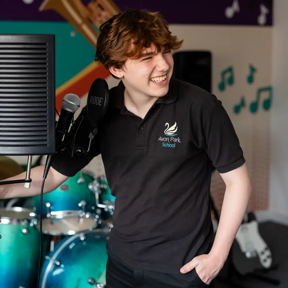 Boy stood next to microphone and music equipment at Avon Park School