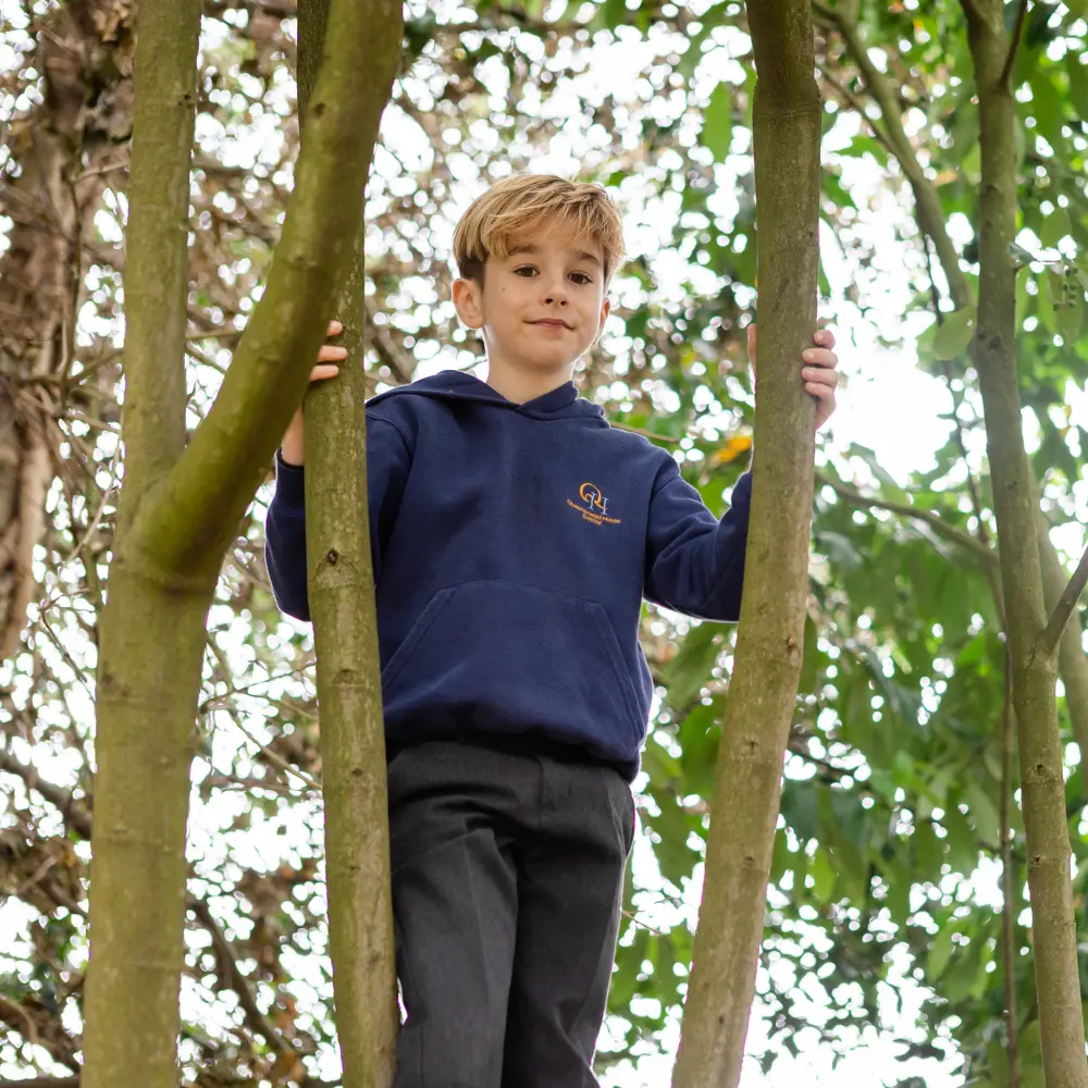 Young boy from Queensmead House School climbing a tree