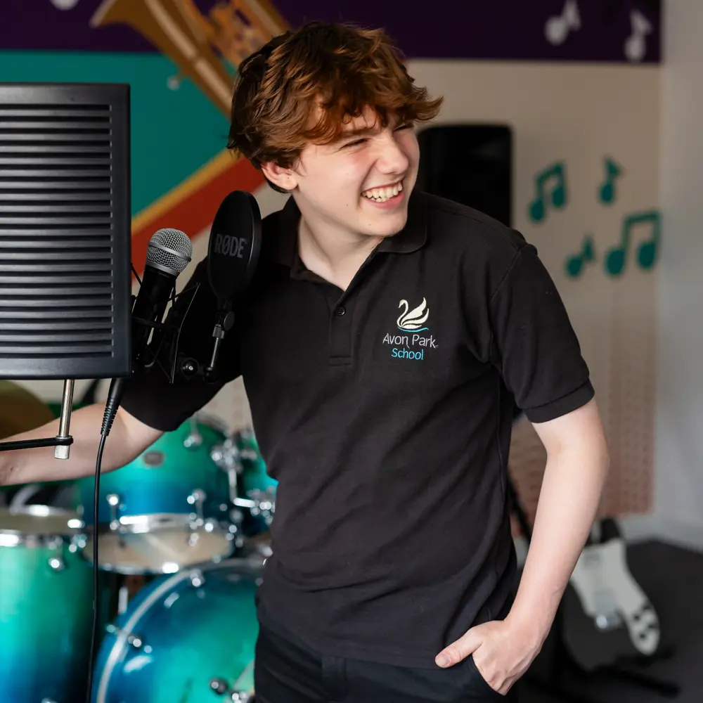 Boy stood next to microphone and music equipment at Avon Park School