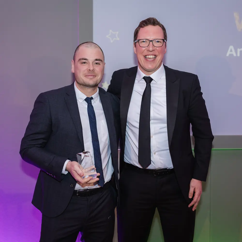 Two male Witherslack Group staff members holding an award at the Star Awards