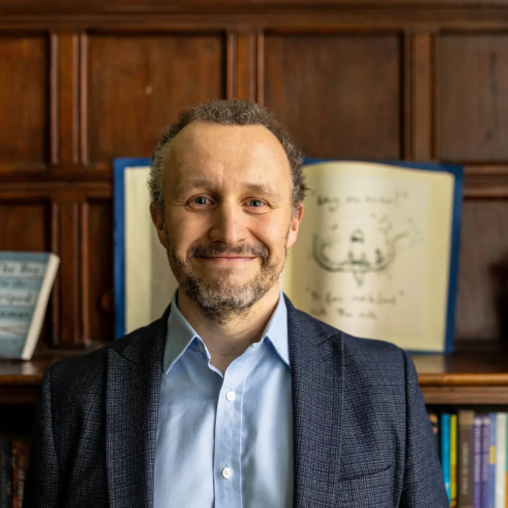 Edward Sherratt, Head Teacher at Oversands School smiling at the camera wearing a suit jacket and shirt