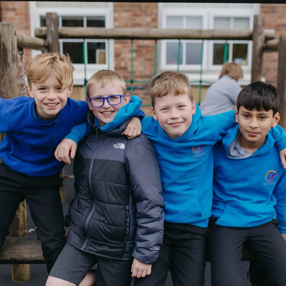 Four young boys from Westmorland School smiling at the camera outside