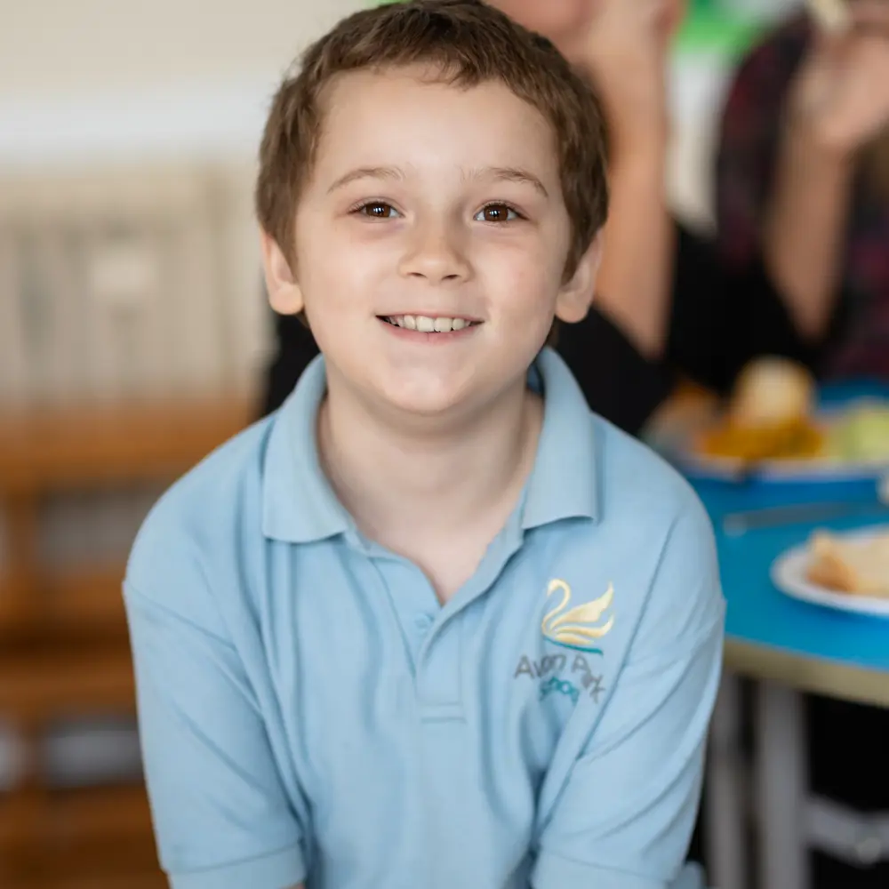 A young boy with brown hair at Avon Park School smiling at the camera