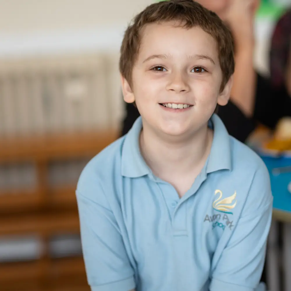 A young boy with brown hair at Avon Park School smiling at the camera