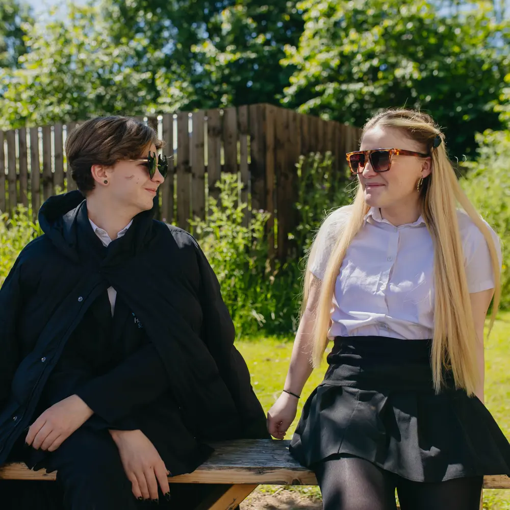 Two girls from Hartwell School sat on a bench outside