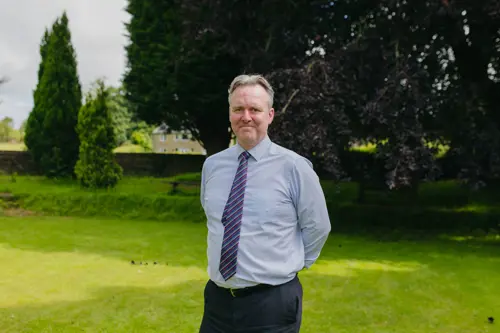 Head Teacher, Stephen Salt from Cedar House School standing in the garden wearing a shirt and tie