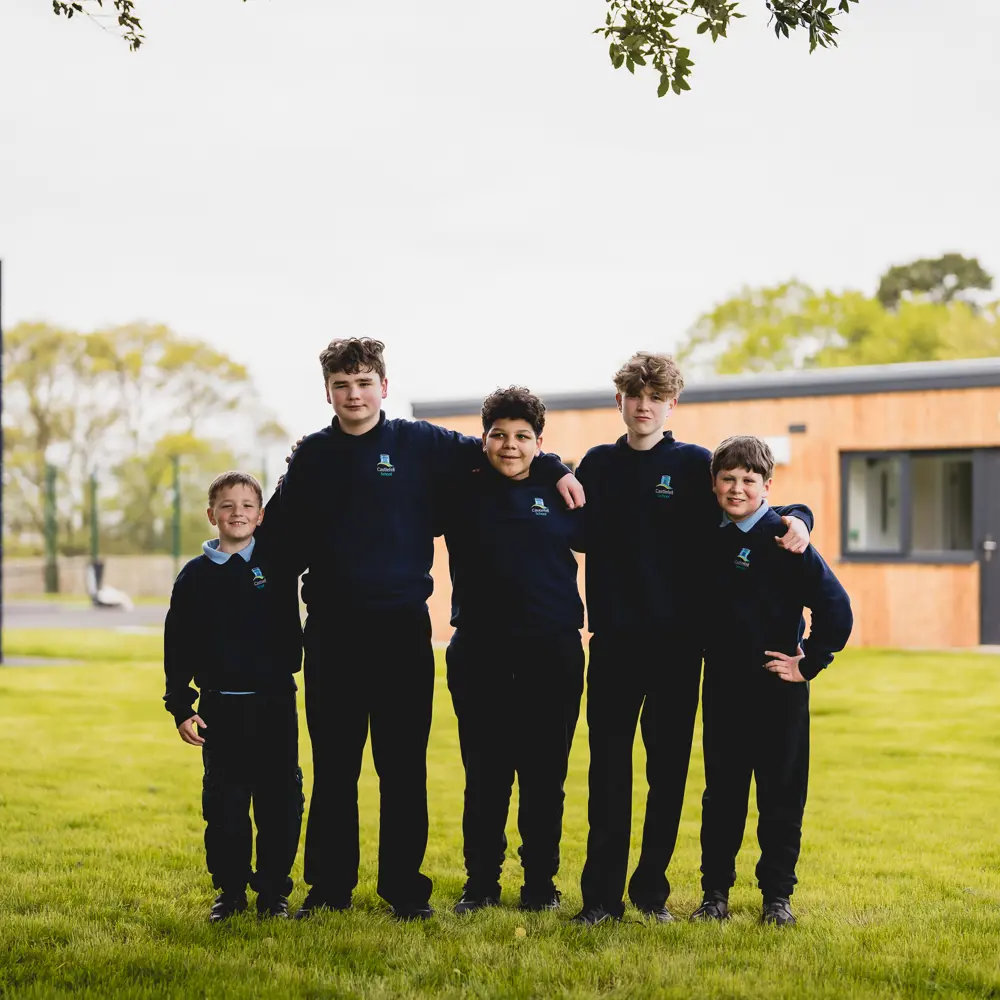 Six boys at Castlefell School outside having their photo taken with their arms around each other smiling