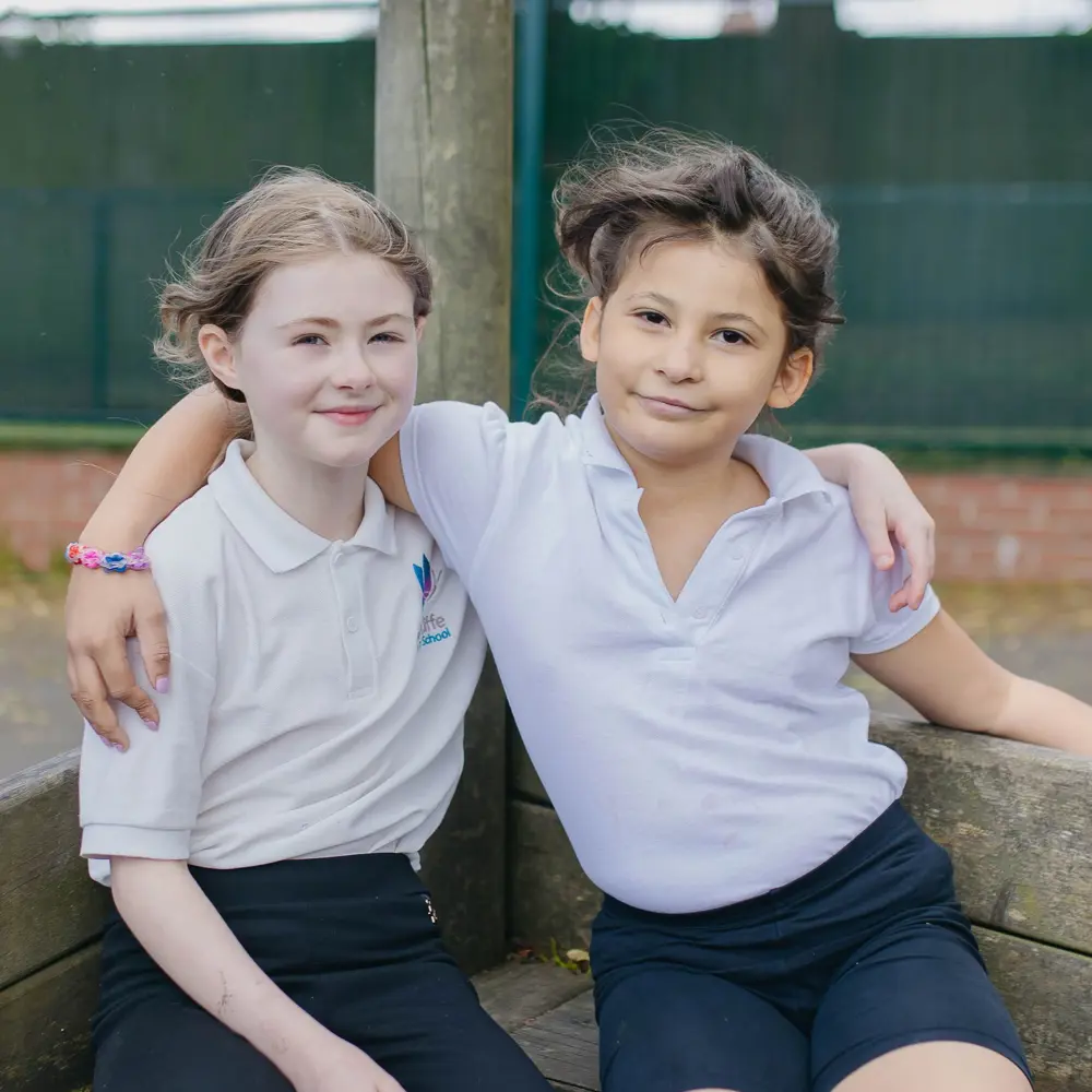 Two girls from Hall Cliffe Primary School sat outside