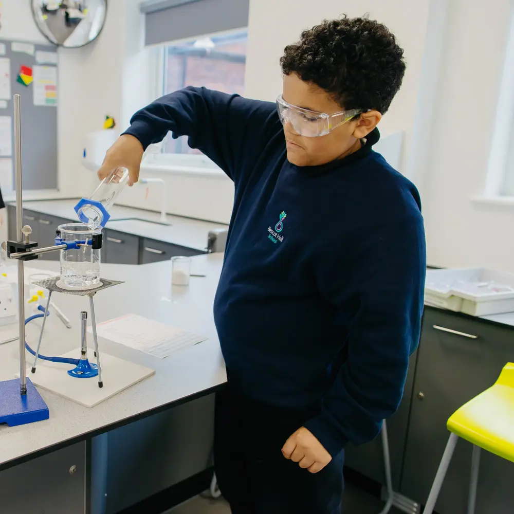 Two boys at Bescot Hall School in a science lesson pouring a chemical into a beaker