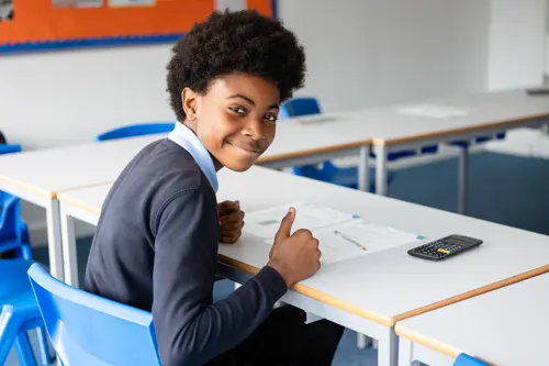 Young boy from Queensmead House School sat at a desk doing school work