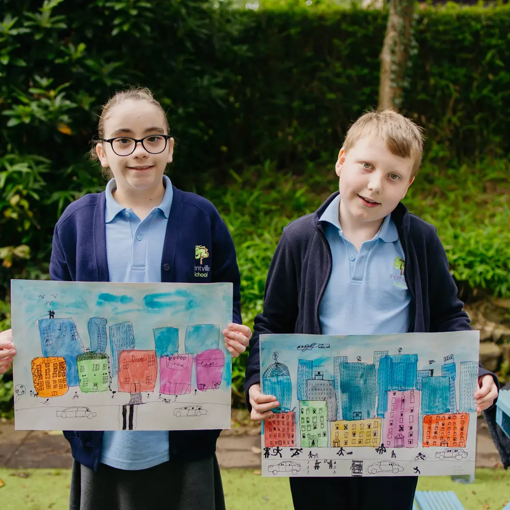 Two pupils one boy one girl, from Pontville School stood next to each other holding up their artwork